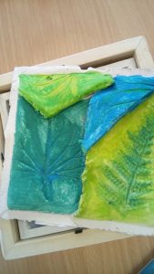 Leaf impressions in clay painted in blue and green colours